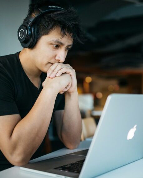homme avec un casque audio surfant sur son ordinateur